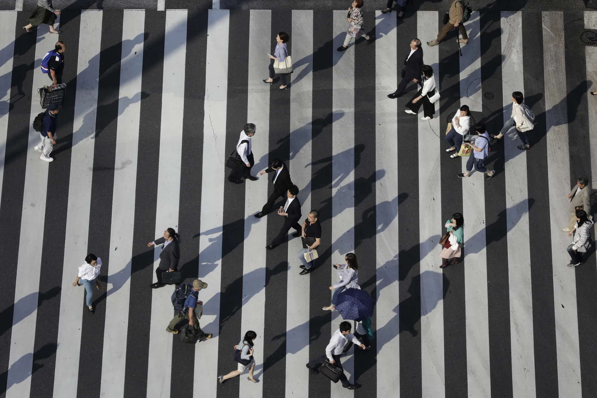 Pedestrians cross an intersection in Tokyo, Japan, on Monday, June 5, 2017. Japan's revised first-quarter gross domestic product (GDP) figures will be released on June 8th.