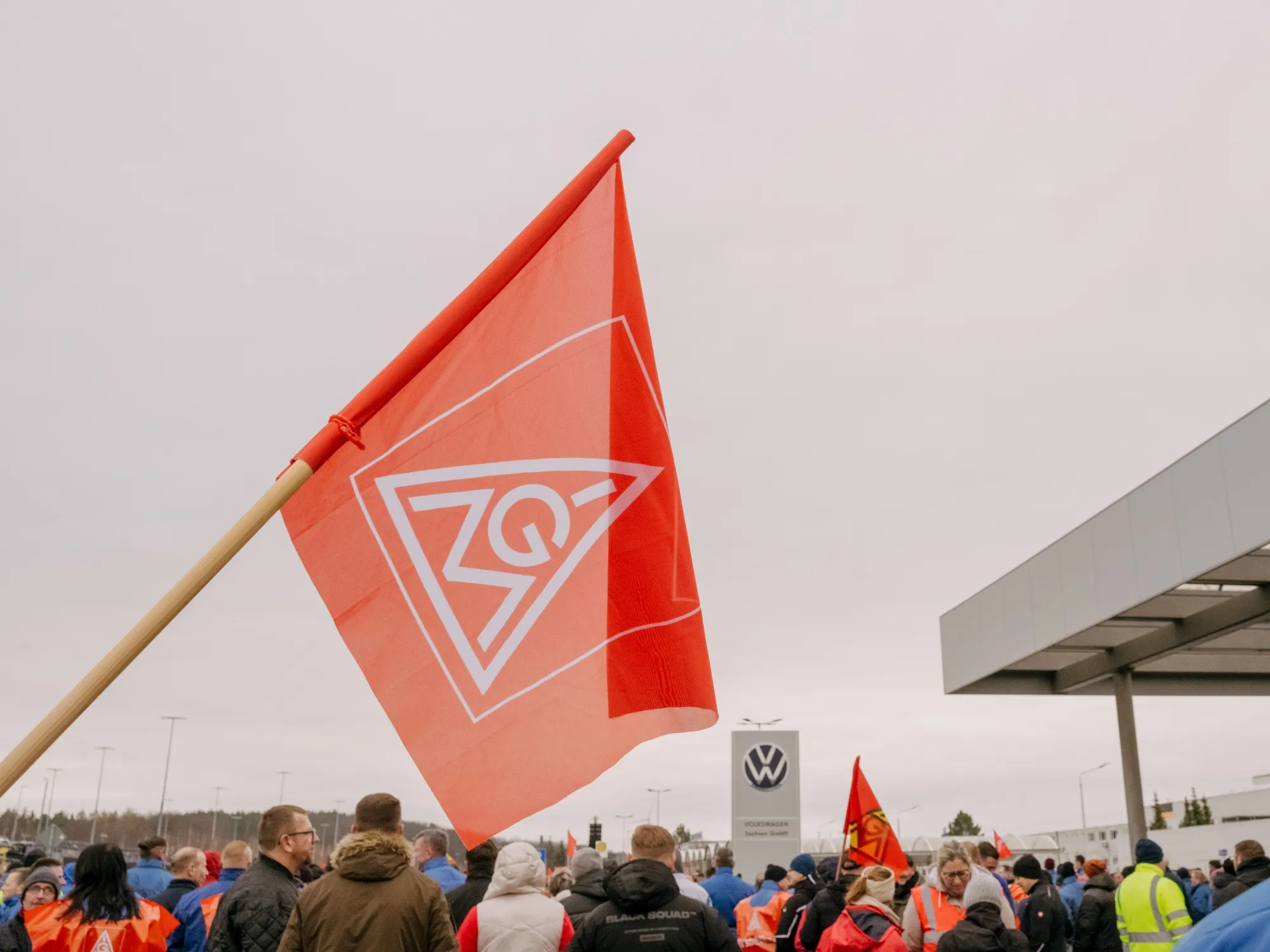 A worker waves an IG Metall union flag during a temporary walkout warning strike at the Volkswagen AG factory in Zwickau, on Dec. 2.