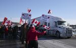 Supporters hold signs as a convoy of trucks passes on the highway in Rigaud, Quebec, Canada, on&nbsp;Jan. 28.