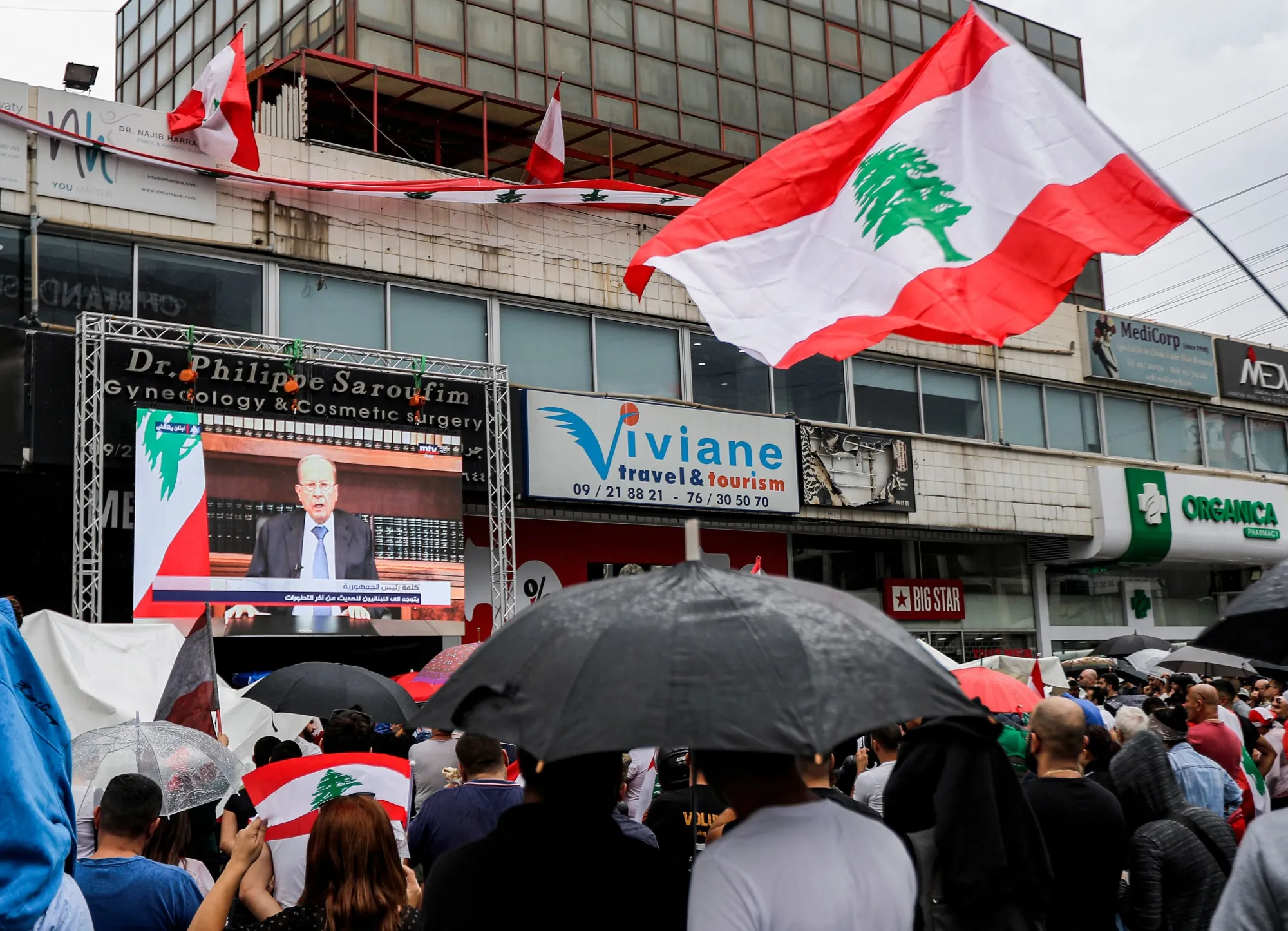People watch a televised speech by President Michel Aoun, in Beirut, on Oct. 24