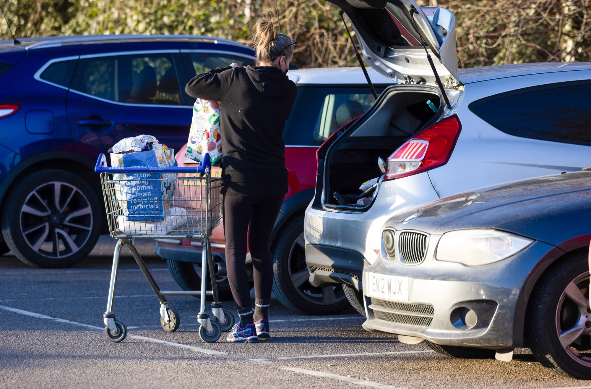 A customer loads shopping into the boot of their car outside a supermarket in Chelmsford.