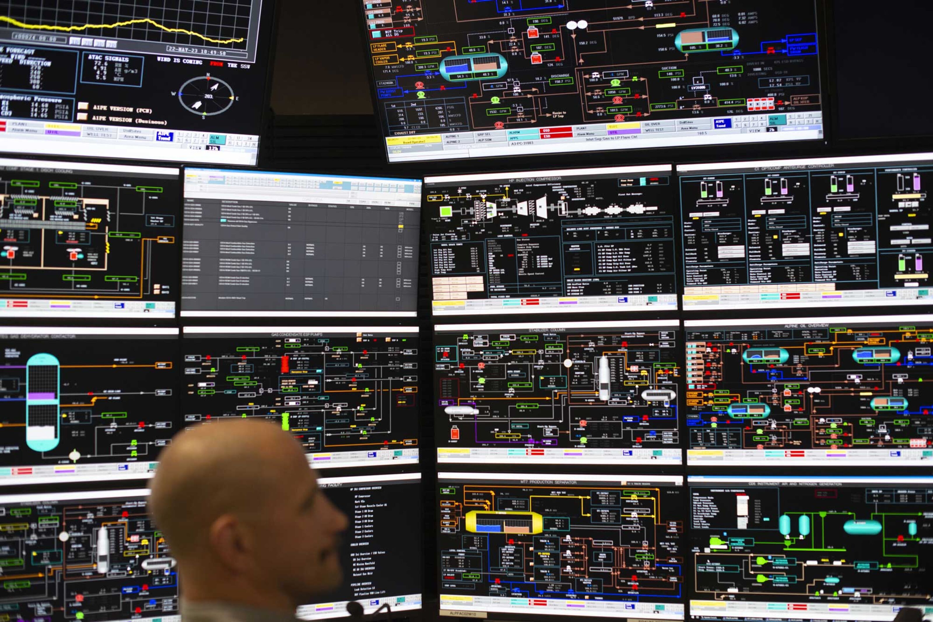 A control room operator watches a wall of screens covered in diagrams and figures, monitoring processing facilities and pipelines at ConocoPhillips’ Alpine oil field on the North Slope of Alaska.