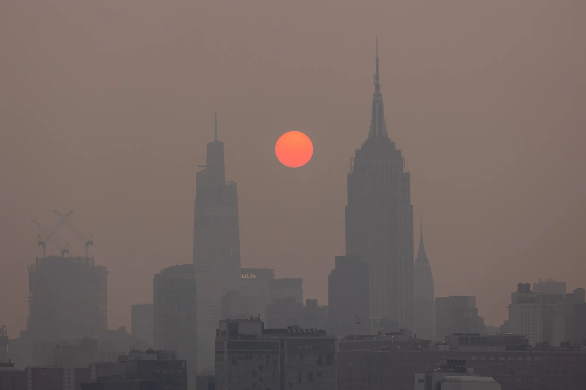 Buildings on the Manhattan skyline shrouded in smoke from Canada wildfires at sunrise, June 7, 2023.&nbsp;