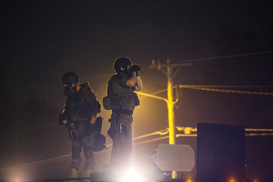 Police in camouflage stand on top of armored trucks in Ferguson, Missouri, during the unrest that followed Michael Brown's death.
