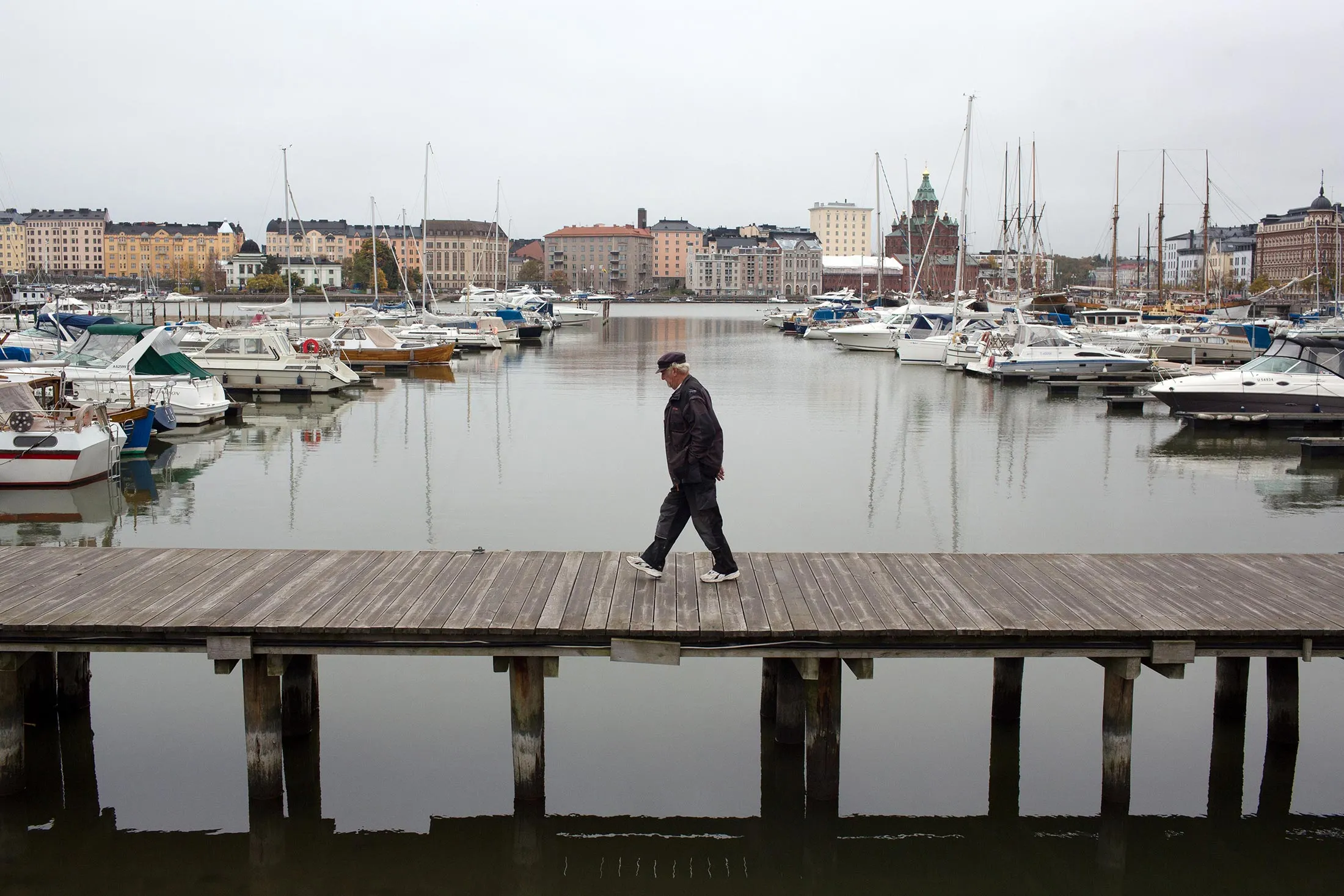 A pedestrian walks along a platform in the south harbor at the port of Helsinki.

