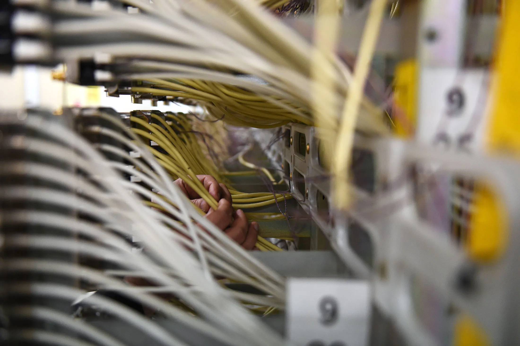 Shoeb Tanveer, technology specialist in the Networks division at Telstra Corp., inspects cable wiring at the Telstra Corp. Exchange equipment building in Melbourne, Australia, on Friday, Aug. 14, 2015. Telstra posted profit that met analysts' estimates as payments for handing over its copper network jumped even as revenue growth from mobile customers slowed amid tougher competition.
