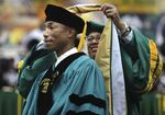 Norfolk State University President Javaune Adams-Gaston bestows Pharrell Williams with an honorary doctorate after he gave the commencement speech, Saturday, Dec. 11, 2021.