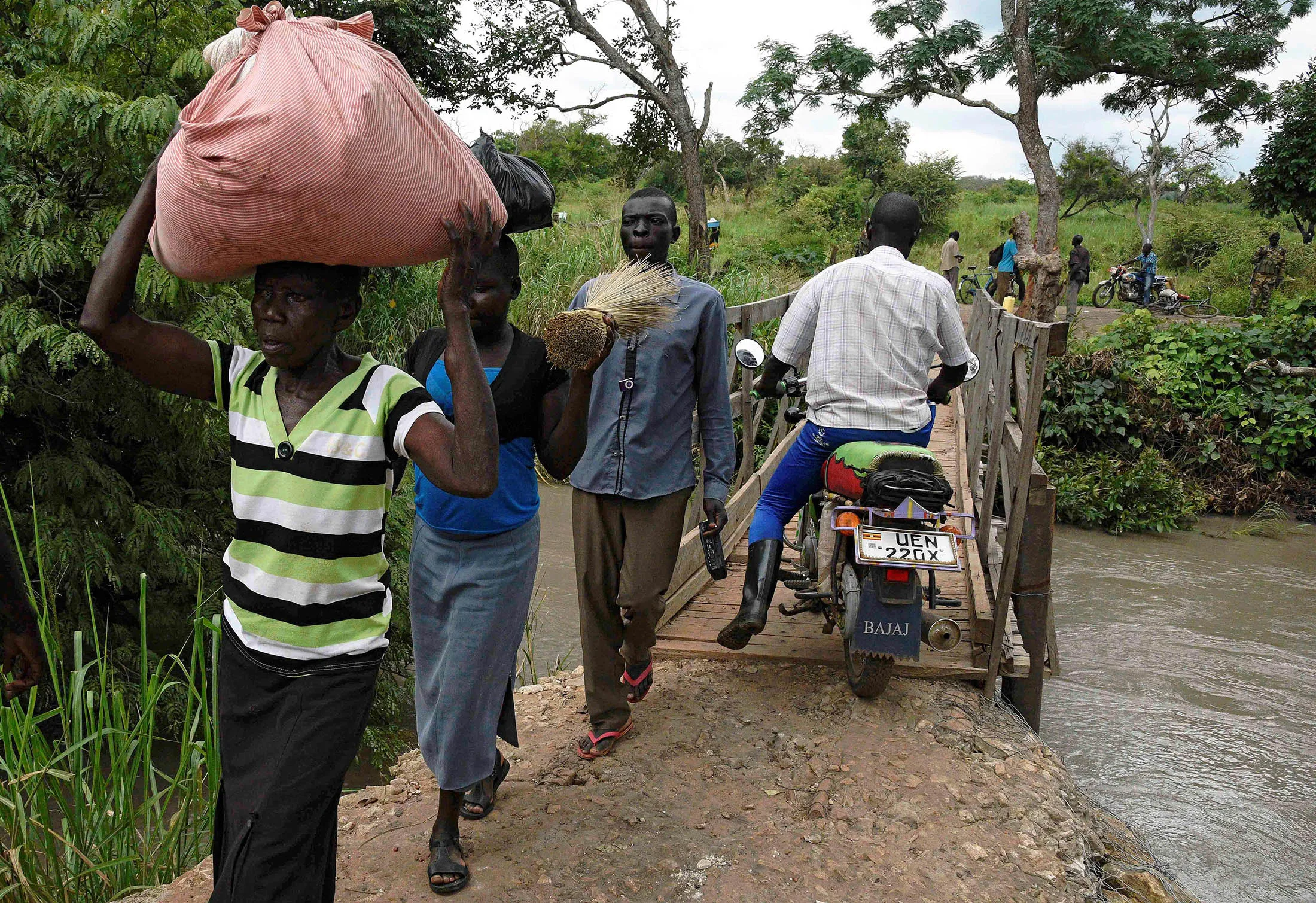 Refugees from South Sudan cross a bridge over the Kaya river at the South Sudanese border point.