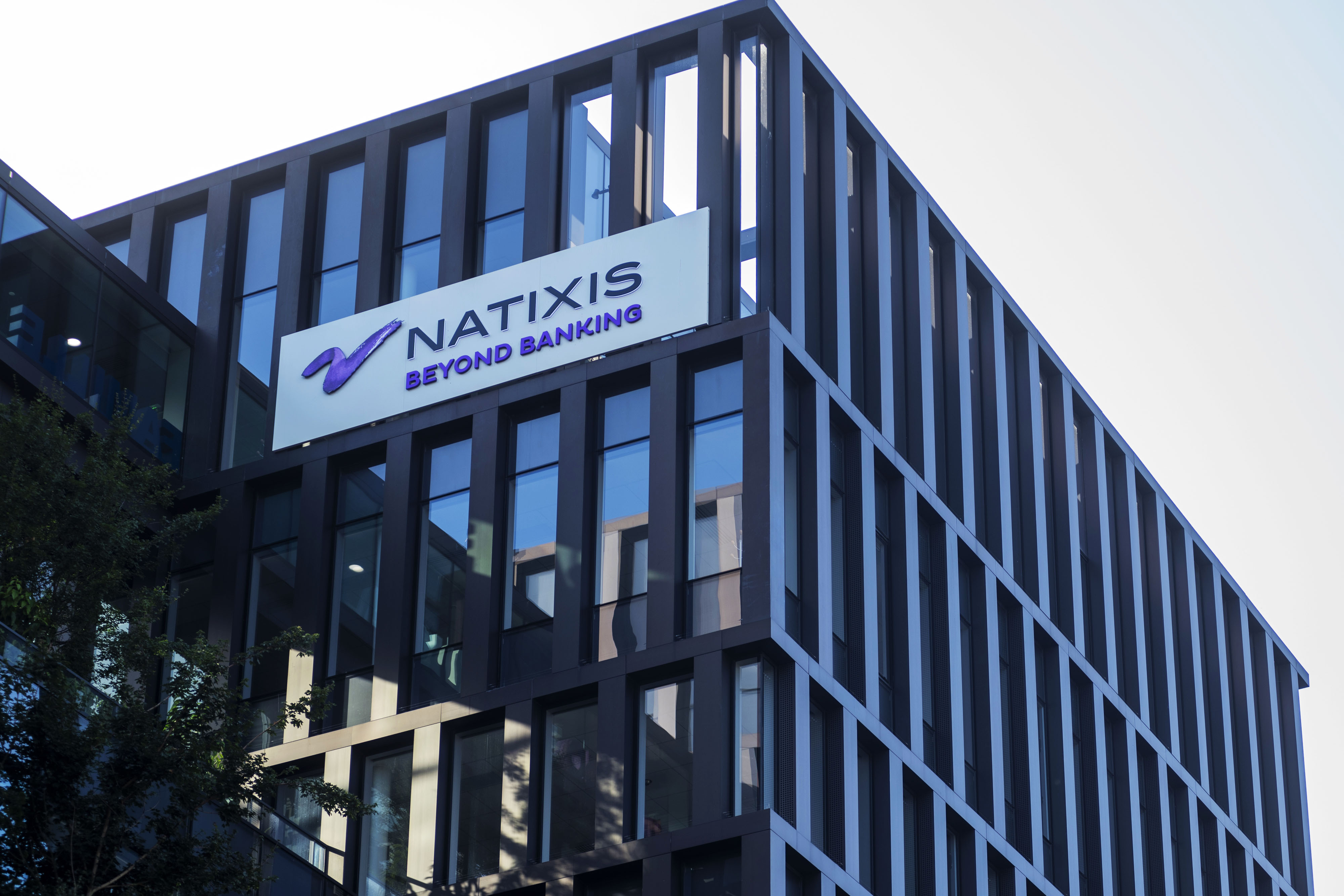 The Natixis SA logo sits on a sign outside the company's headquarters in Paris.
