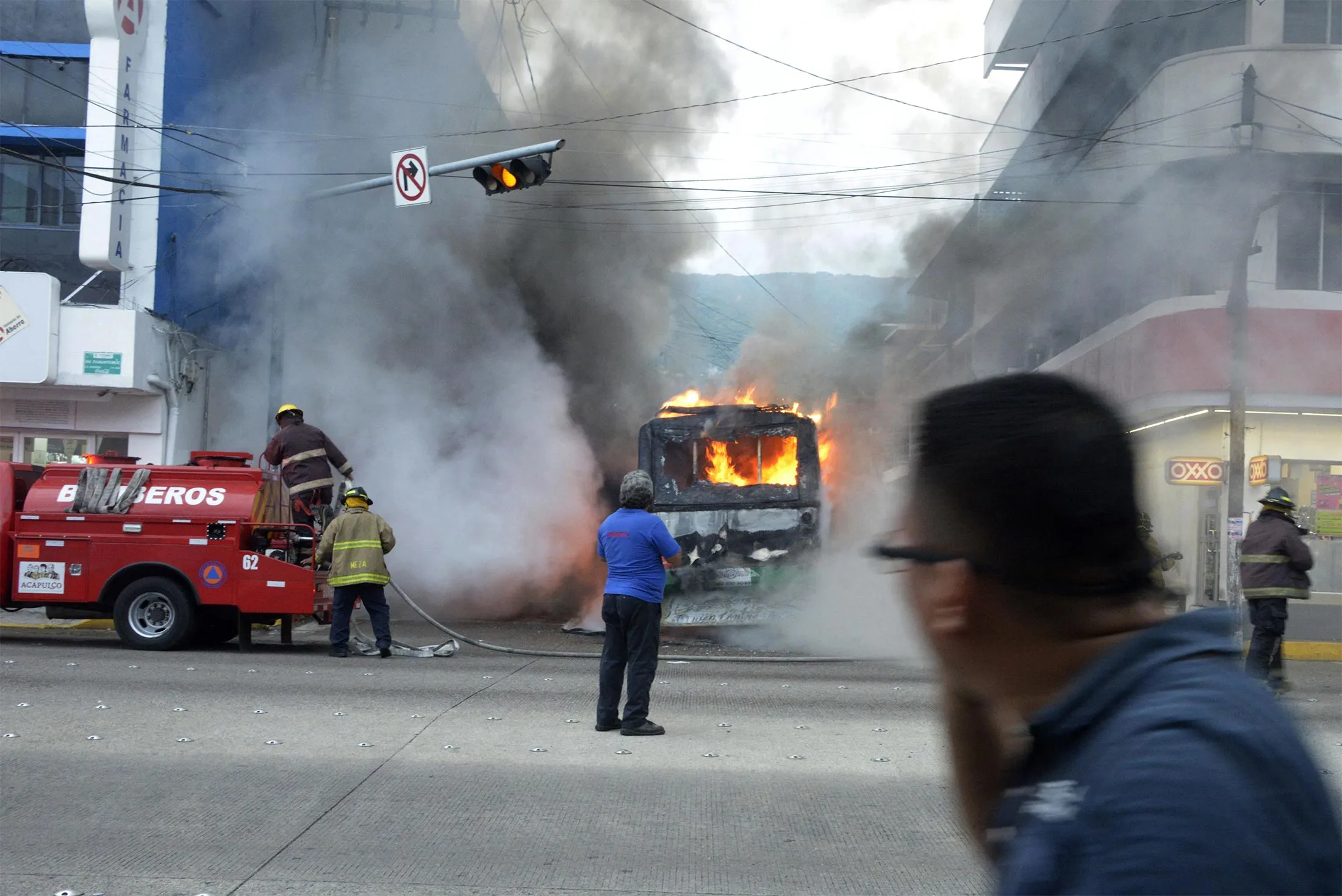 Firefighters work to extinguish a burning vehicle in Acapulco, Guerrero State, Mexico, on Aug. 2.