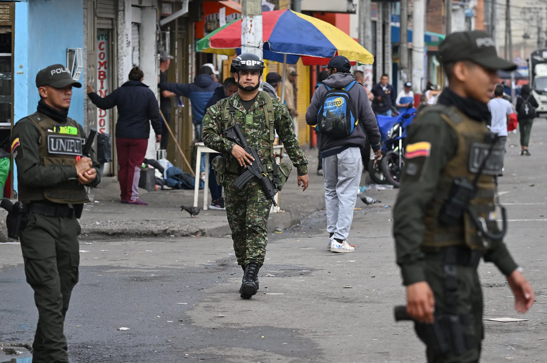 Colombian police officers and a soldier patrol the San Bernardo neighborhood near the site of a grenade explosion in Bogota on March 13.