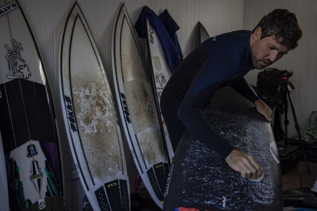 A surfer waxes a board at Beyond The Club. 