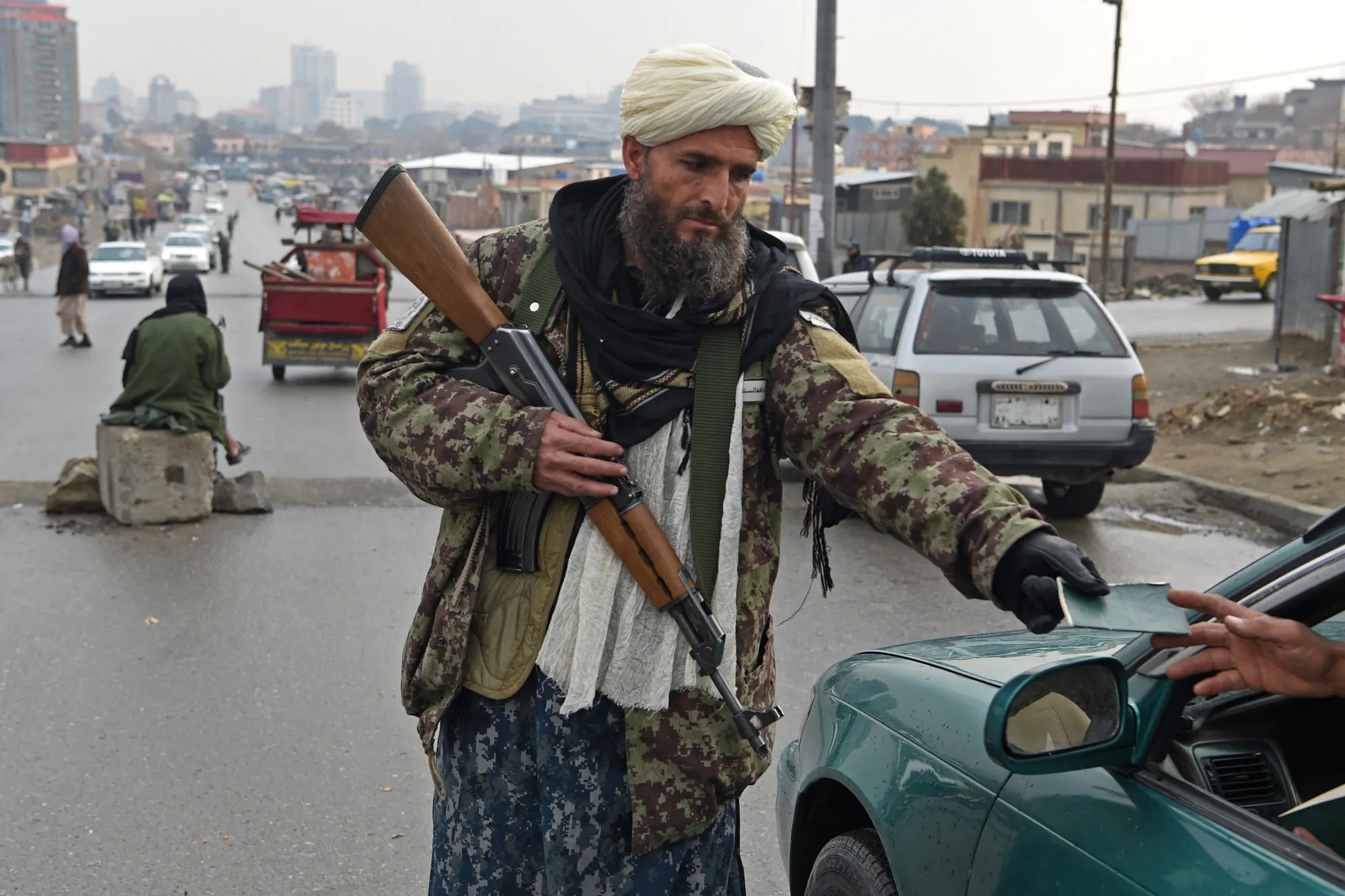 A Taliban fighter checks the document of a motorist at a checkpoint in Kabul on Dec.&nbsp;23.