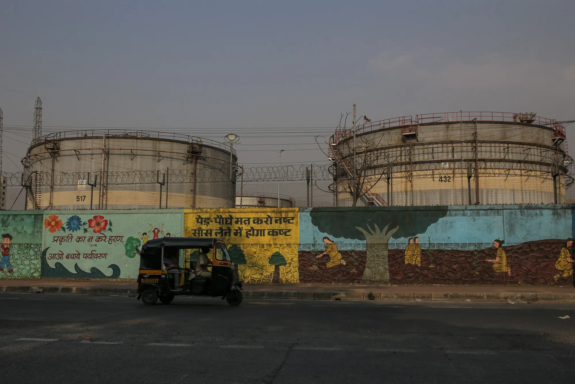 An auto rickshaw drives past a Bharat Petroleum oil refinery in Mumbai, India.