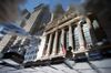 The New York Stock Exchange (NYSE) is reflected in a puddle in New York, U.S.