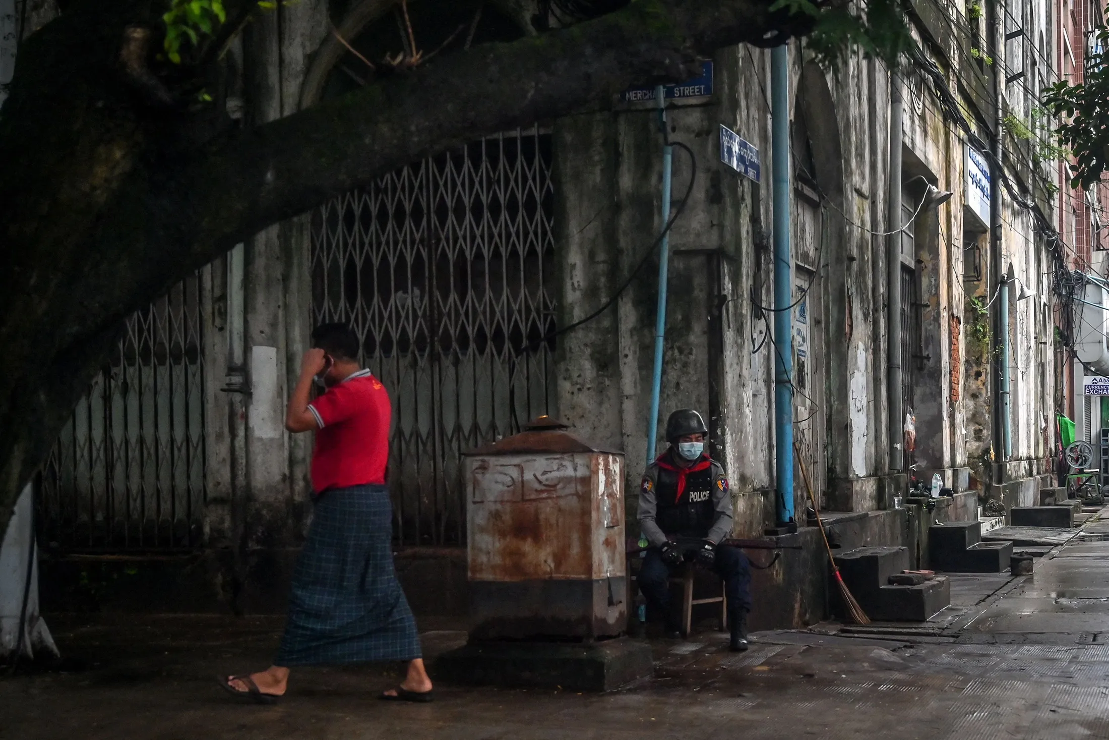 A member of the Myanmar security forces sits along a street in Yangon on July 19.