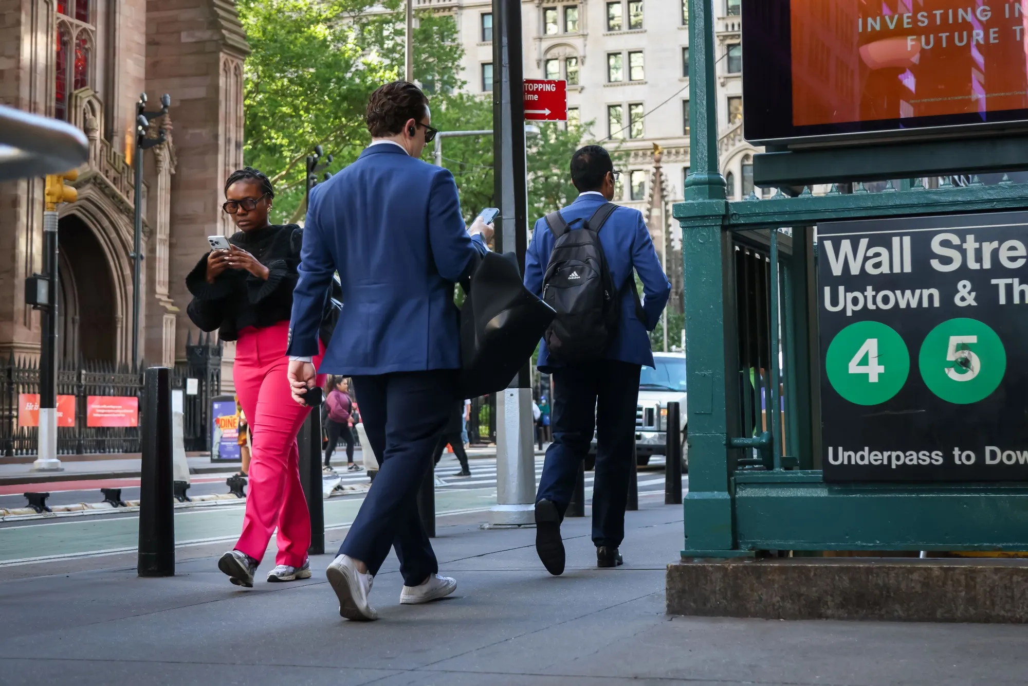 Pedestrians pass a Wall Street subway station near the New York Stock Exchange (NYSE) in New York, US.