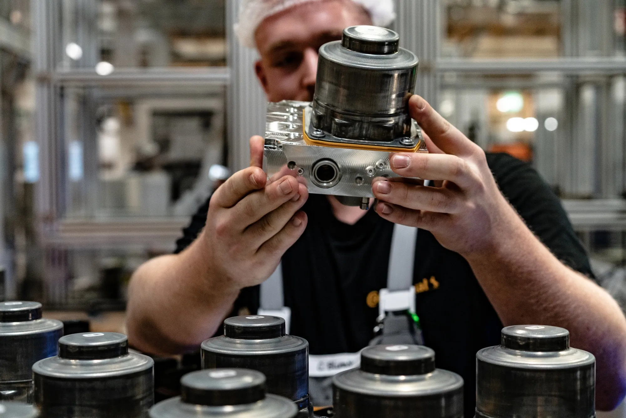 An employee checks a cylinder component for a brake system module at&nbsp;the Continental AG manufacturing plant in Frankfurt.