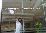 A man polishes a logo for JPMorgan Chase & Co. at their main office in Bangkok, Thailand, on Tuesday, May 22, 2007.