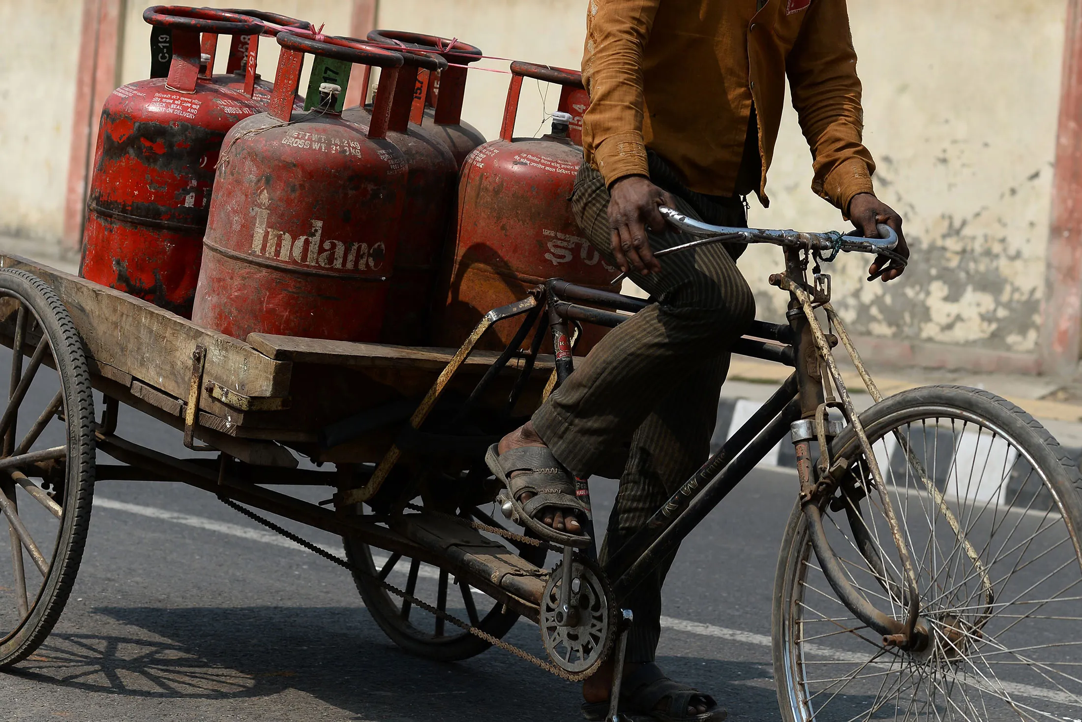 An Indian Liquid Petroleum Gas (LPG) vendor carries gas cylinders on a cycle rickshaw outside a depot in New Delhi on February 29, 2016.
