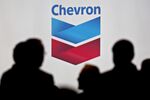 Attendees stand near Chevron signage during the World Gas Conference in Washington.