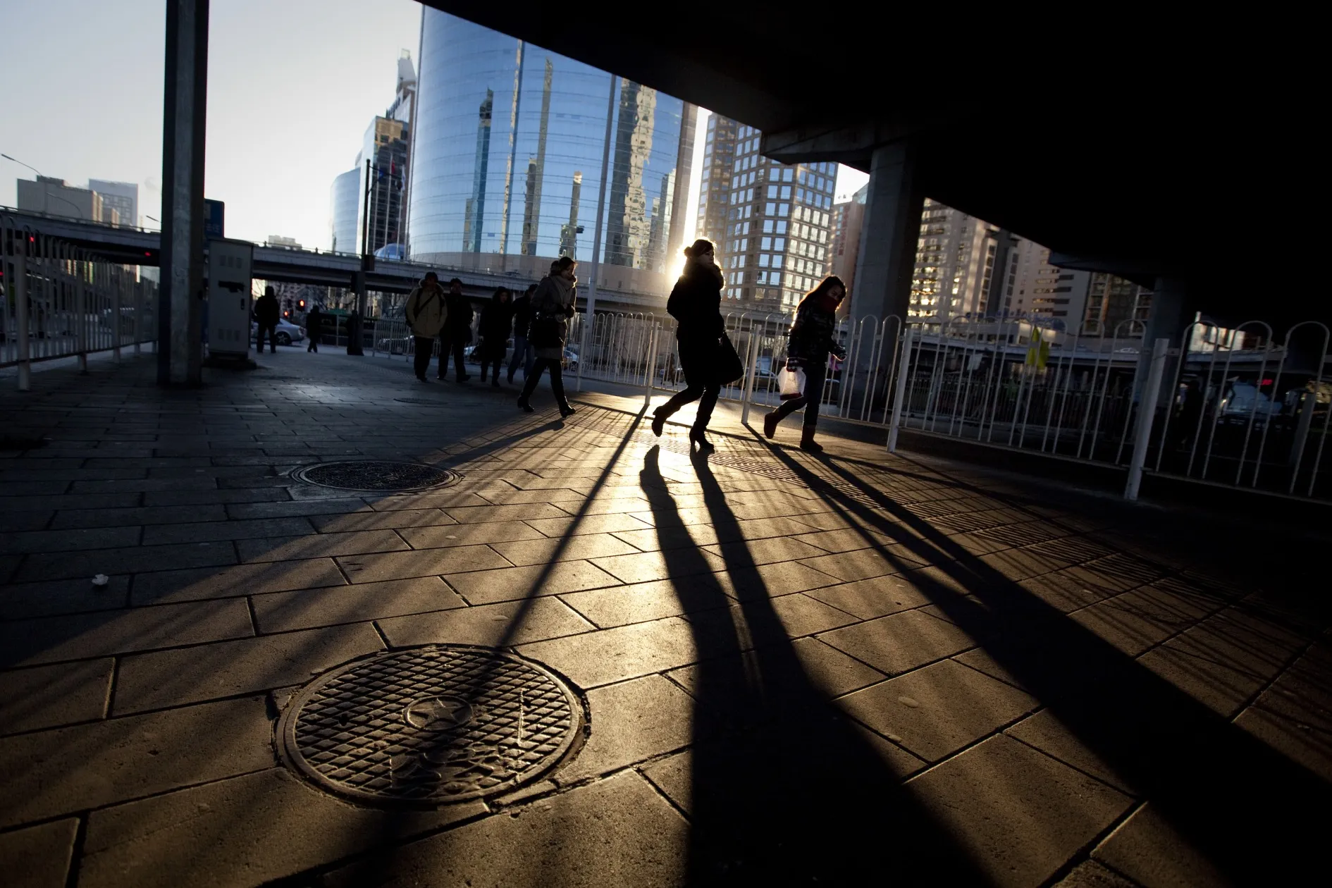 Commuters walk through the central business district in Beijing, China.