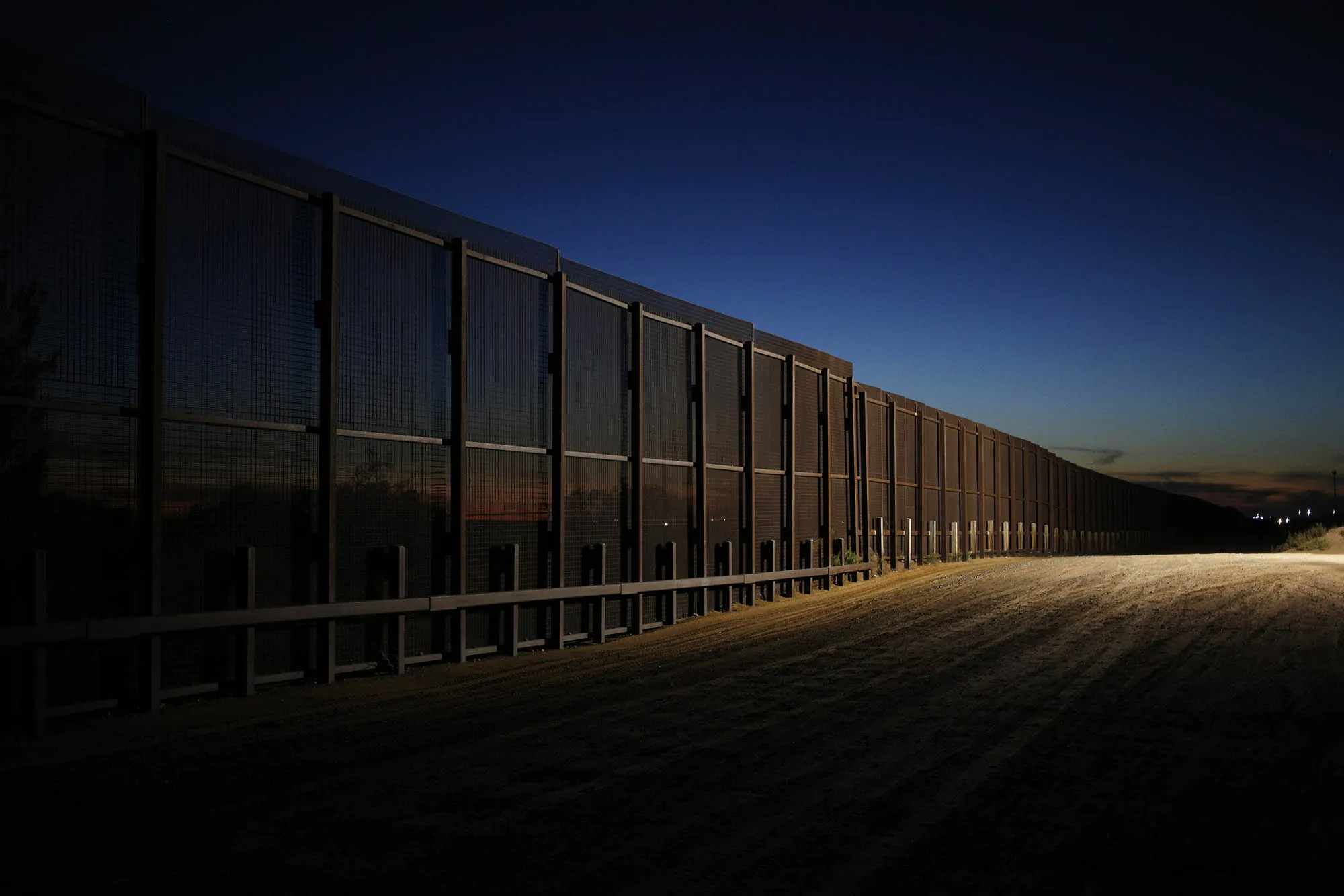 A border fence that separates the U.S. and Mexico stands at sunset in Santa Teresa, New Mexico.
