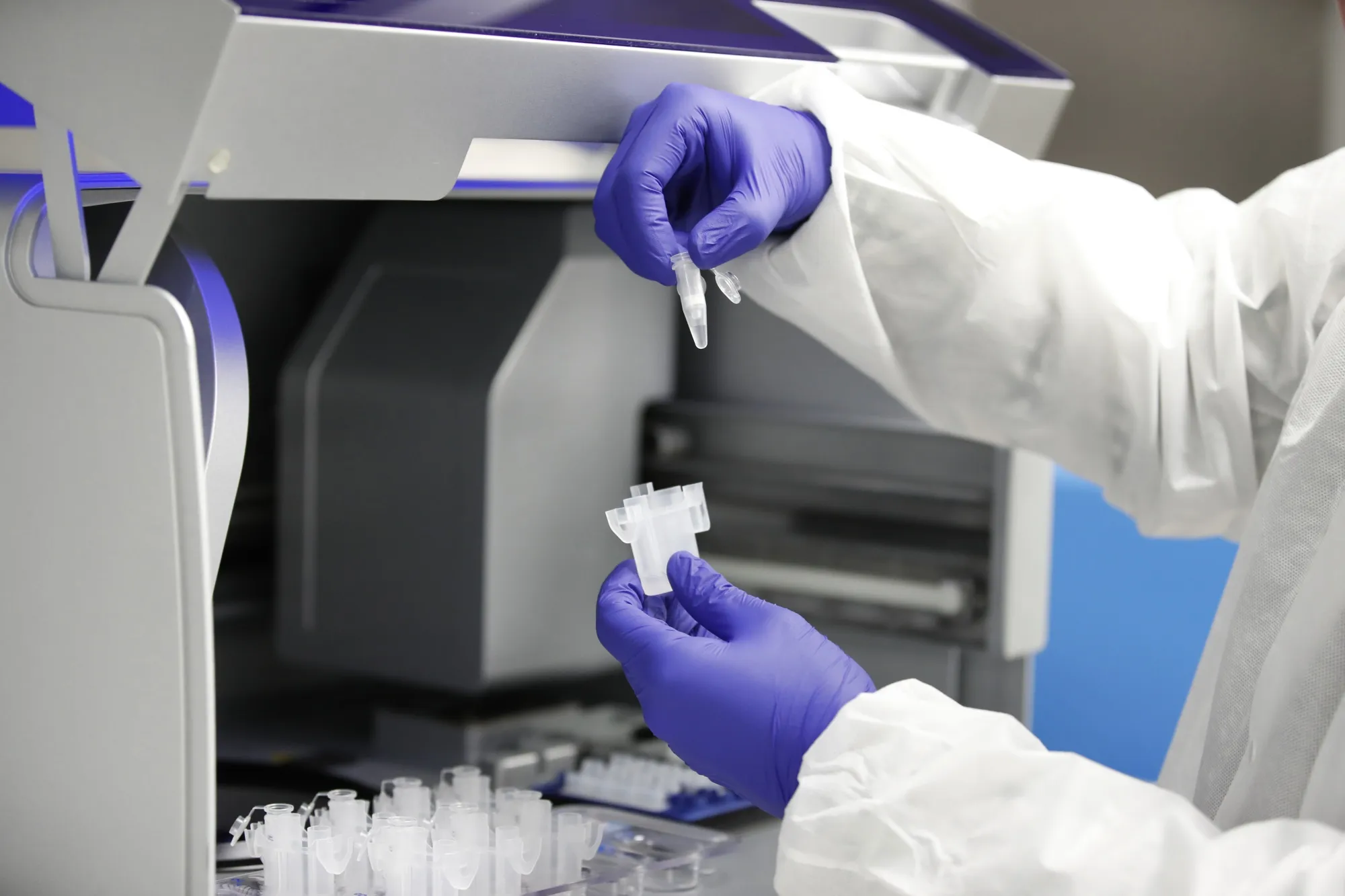 A lab technician removes vials from an automated extraction machine for Covid-19 virus testing at a Co-Diagnostics facility in Salt Lake City.