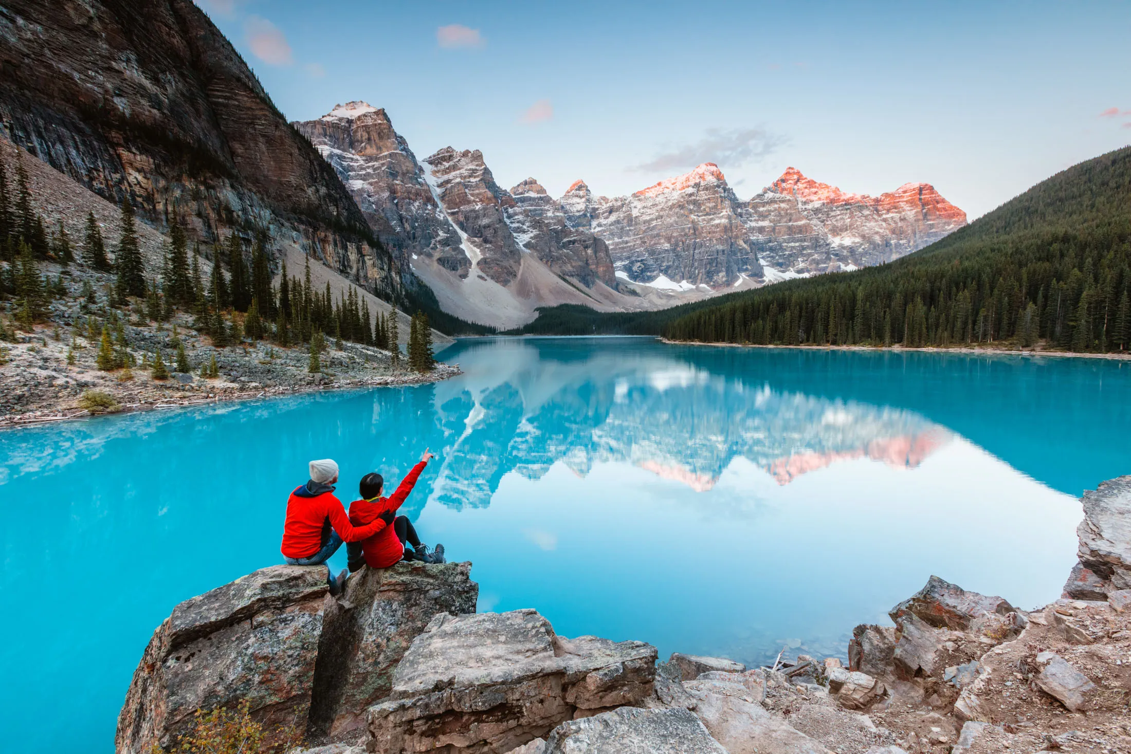 Couple looking at Moraine lake at dawn, Banff National Park, Alberta, Canada.