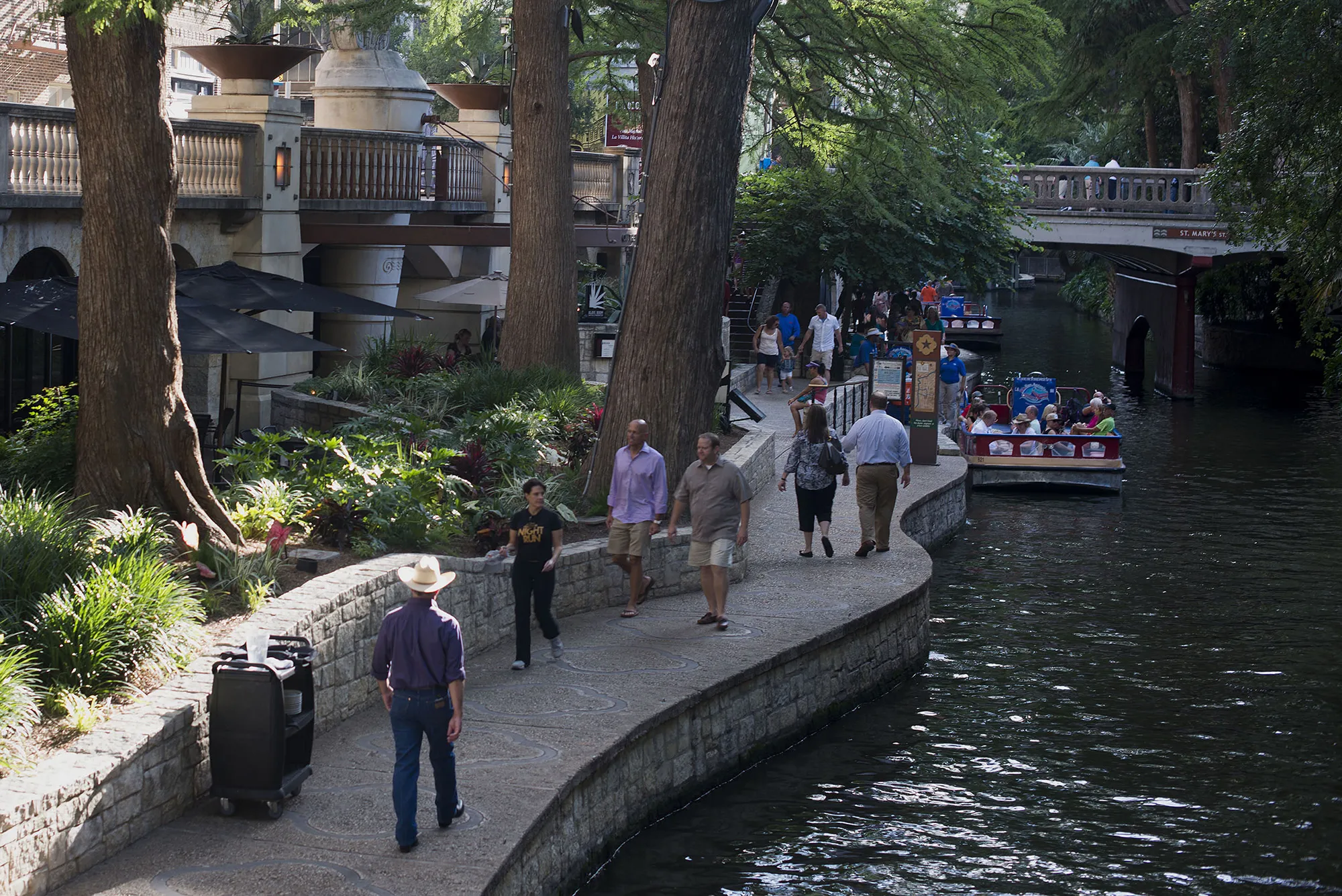 Shoppers and tourists walk along the river walk in downtown San Antonio, Texas.