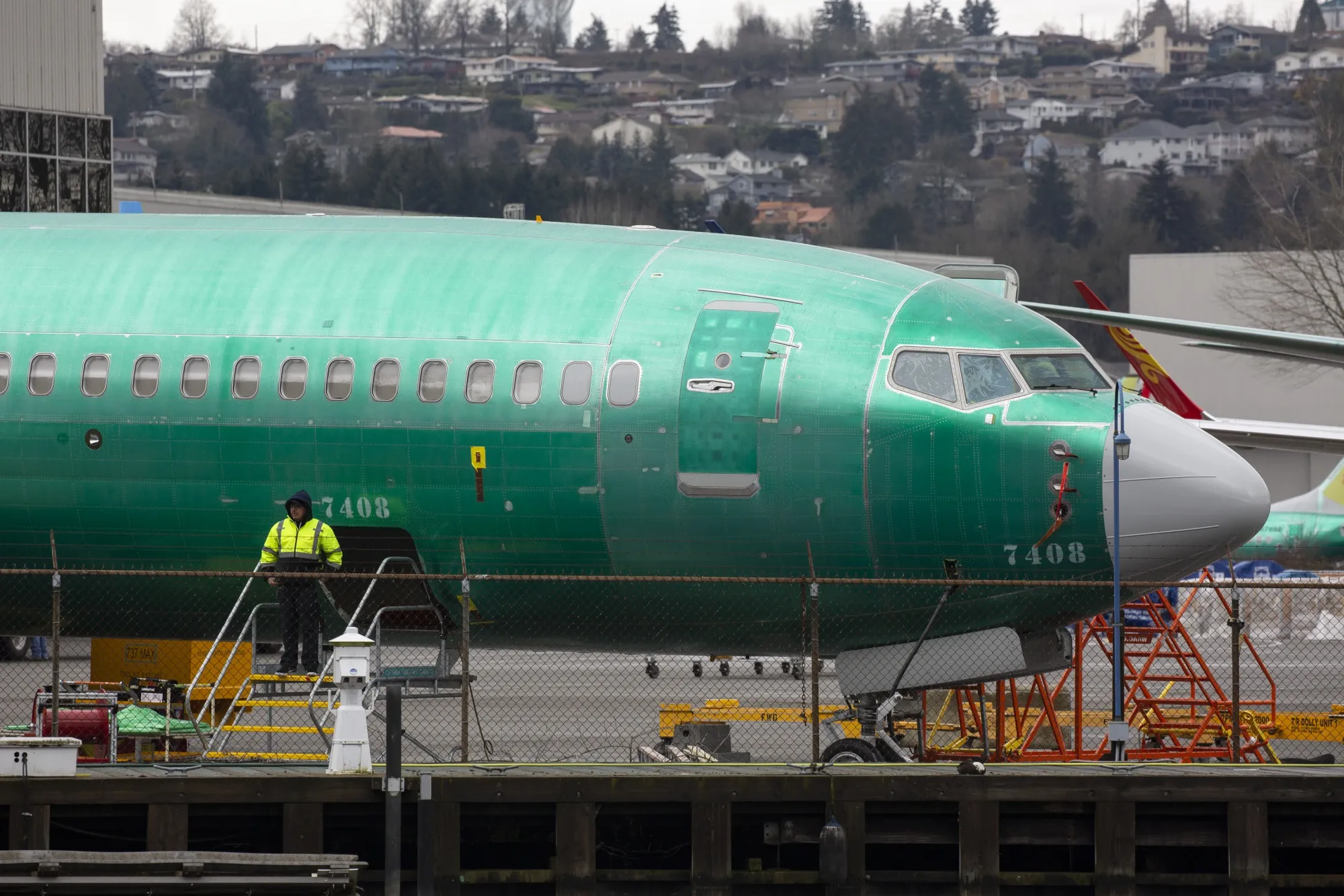 An employee stands next to a 737 Max 8 plane at the Boeing Co. manufacturing facility in Renton, Washington, on March&nbsp;12, 2019.&nbsp;