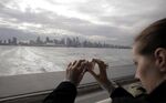 A tourist takes a photo of the Vancouver skyline. The Canadian city expects 10 million visitors this year.