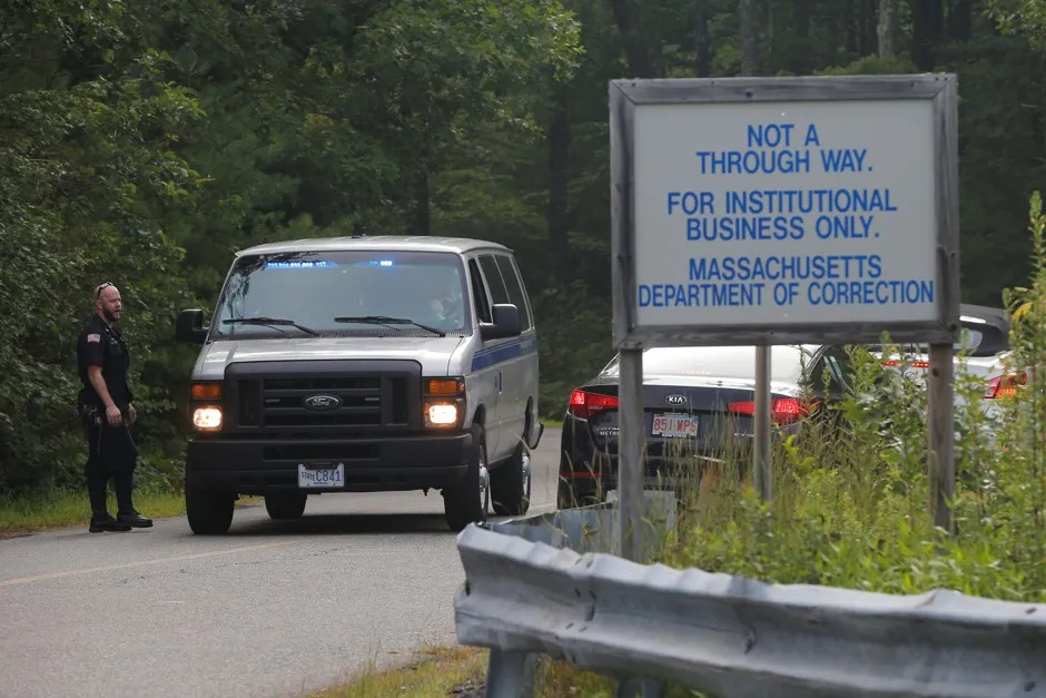Officers check cars at a correctional center in Bridgewater, Massachusetts.