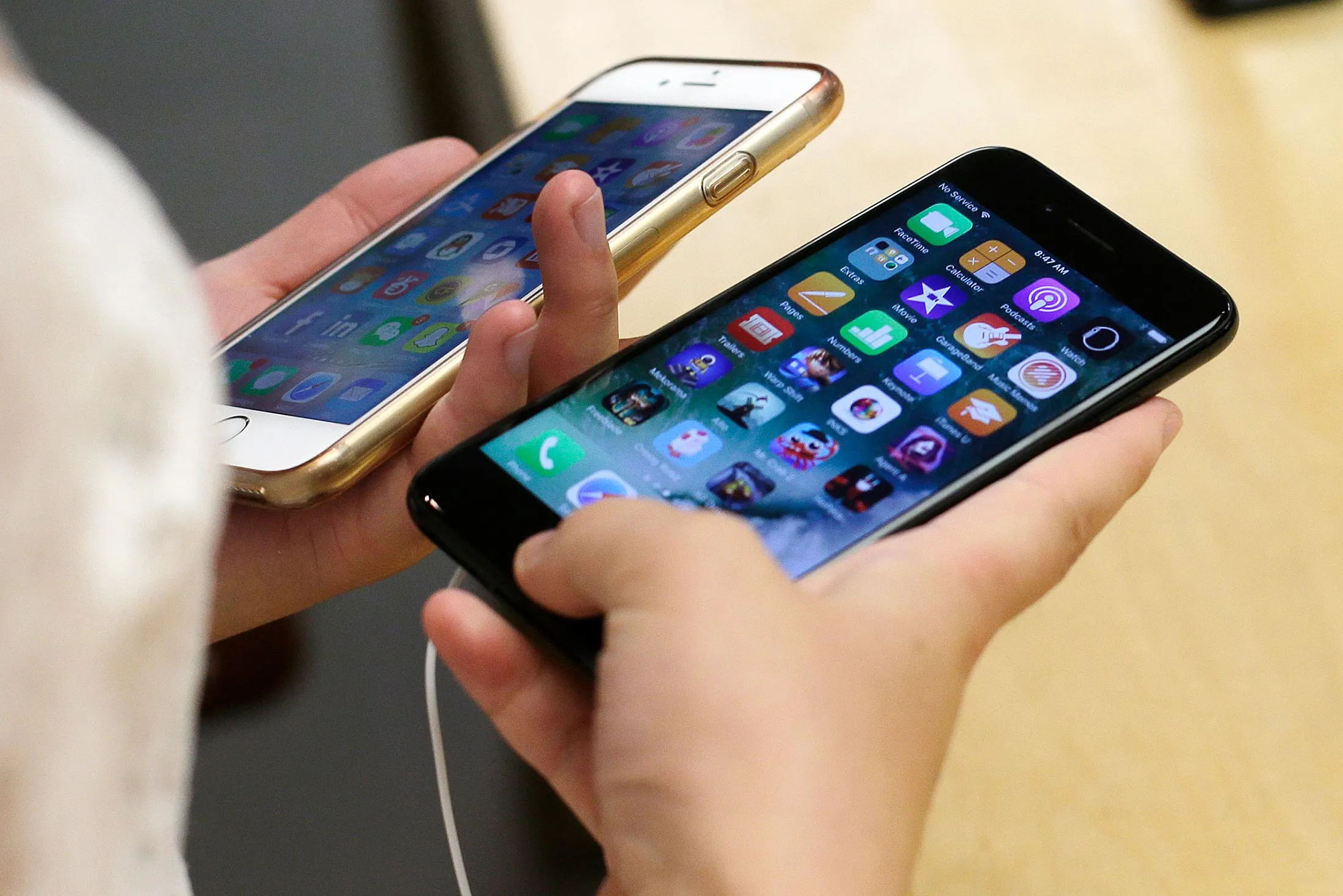 In this Sept. 16, 2016, file photo a woman compares a new jet black iPhone 7, right, with her iPhone 6 at an Apple Store in Chicago.
