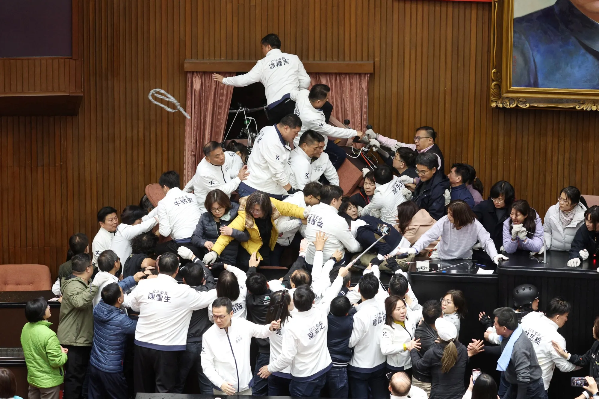 Lawmakers from the KMT, in white, try to break into the legislature occupied by DPP lawmakers in Taipei on Dec. 20.