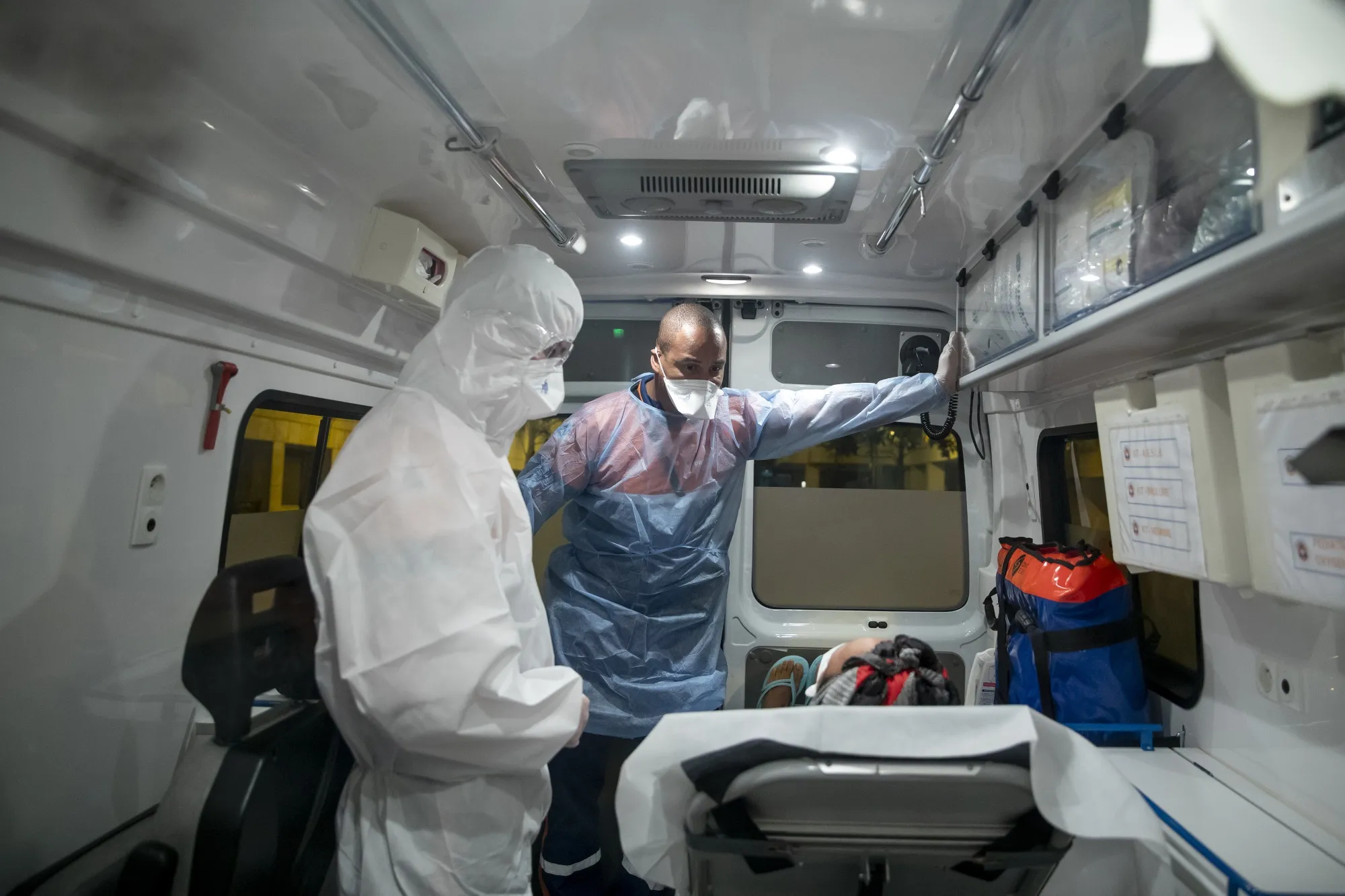 Civil Protection (FNPC) ambulance crew members, wearing personal protective equipment, assist a patient in&nbsp;Paris, France, on&nbsp;April 21.