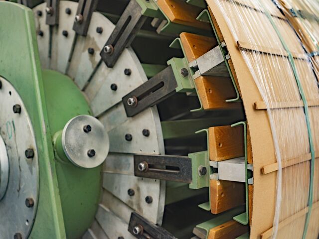 Close-up of the wood structure being rotated as wires are wound.