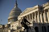 A bicyclist rides past the U.S. Capitol in Washington, D.C., U.S..
