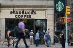 Pedestrians stroll by a Starbucks Coffee shop in Union Square in New York.
