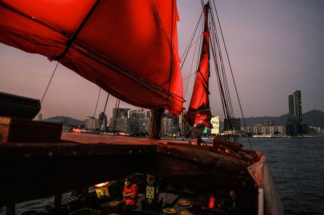 A deckhand sits on the lower deck of a traditional wooden tourist junk boat "Dukling," built in 1955 as it sails in the waters of Victoria Harbour in Hong Kong, Nov. 27, 2020.