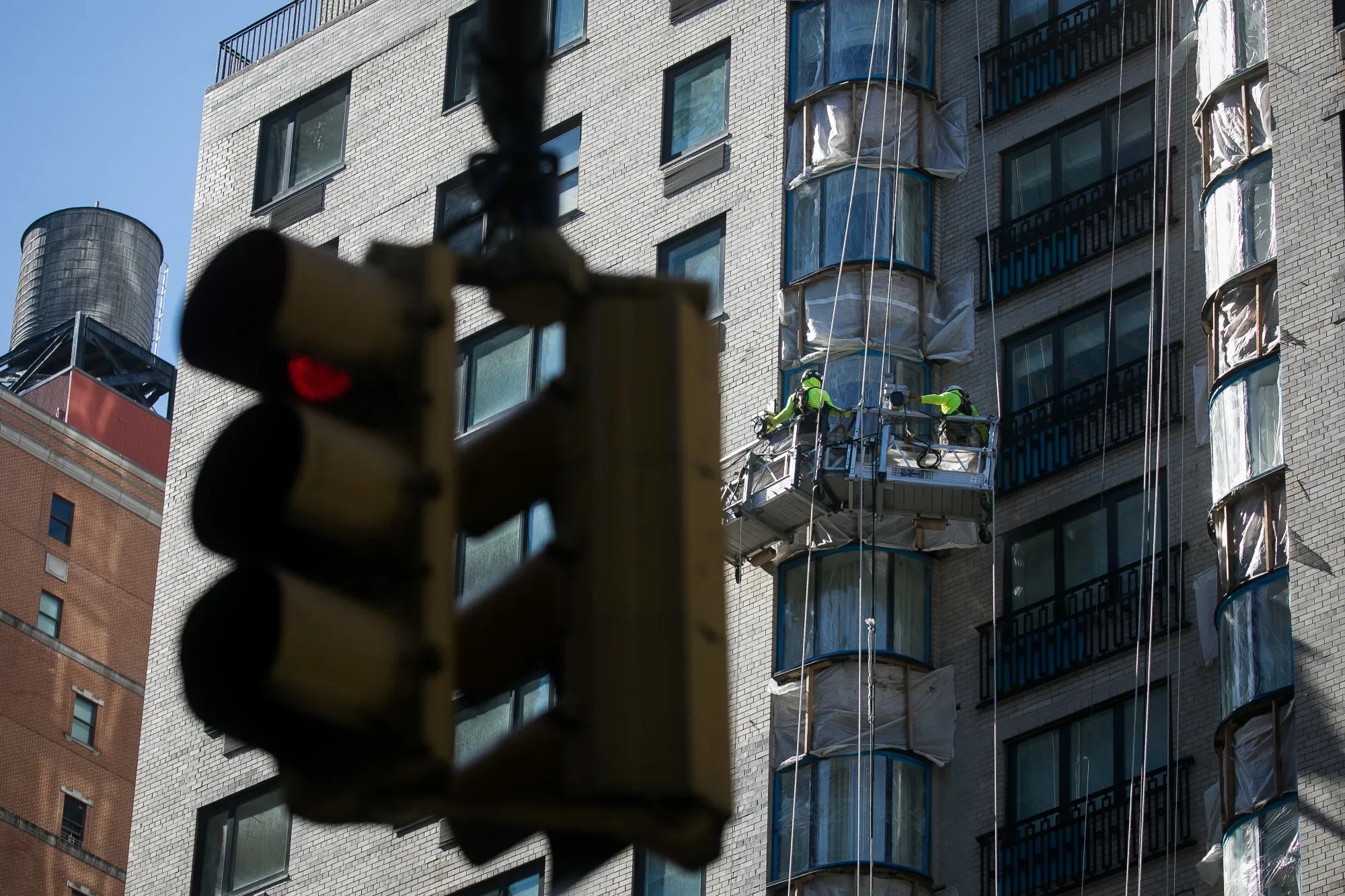 Contractors repair the exterior of an apartment building in New York, US.