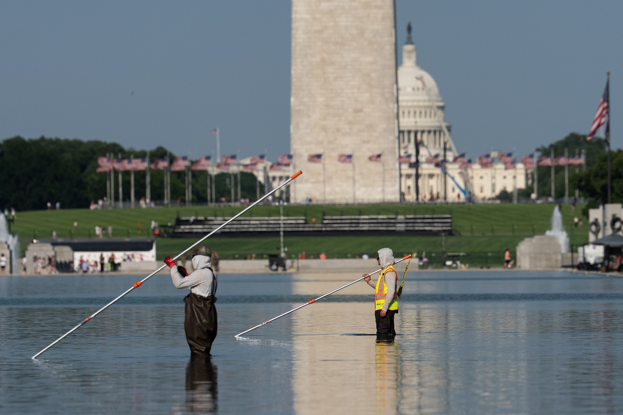 Workers clean algae from the Lincoln Memorial Reflecting Pool after it was painted blue in Washington, DC, US, on Wednesday, June 17, 2026. A Washington federal judge wrestled with how reversible President Donald Trump's efforts to change the color of the Lincoln Memorial Reflecting Pool would be, in the latest lawsuit targeting Trump's moves to renovate some of Washington's historic landmarks. Photographer: Aaron Schwartz/Bloomberg 
