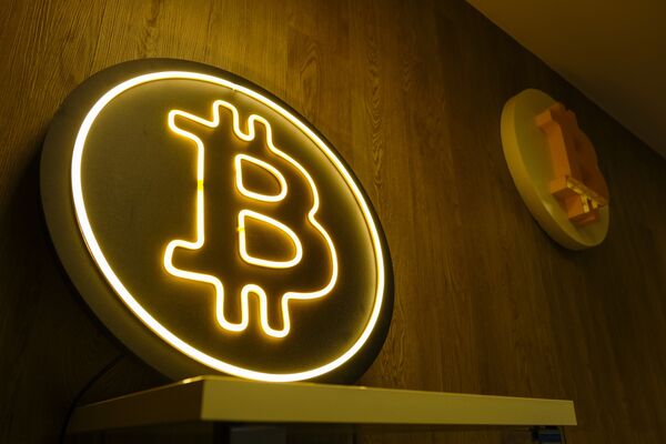 A neon Bitcoin cryptocurrency logo.