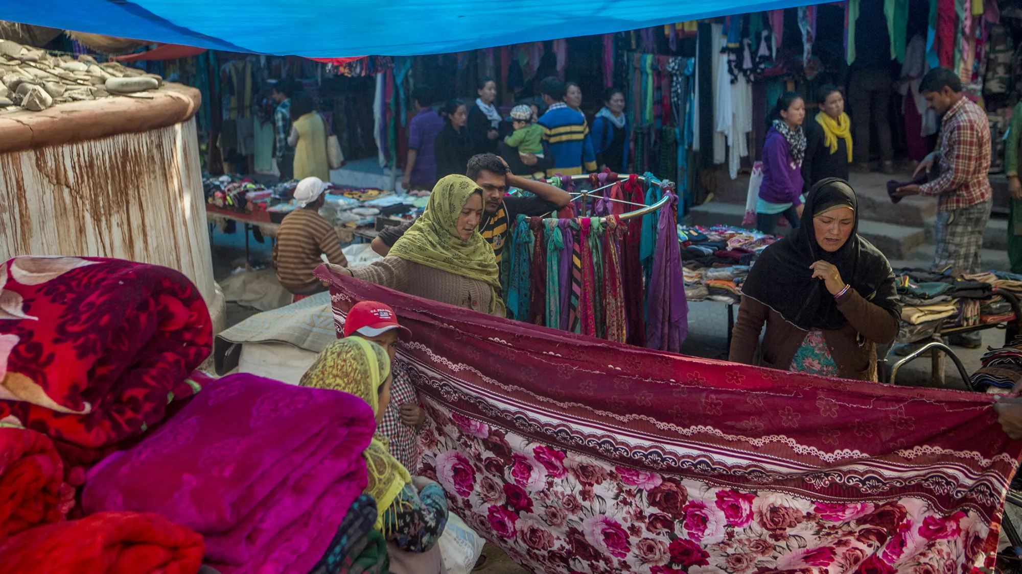 Shoppers look at a length of fabric at a market in Leh, Jammu and Kashmir, India, on Wednesday, Aug. 5, 2015. India is scheduled to release second-quarter gross domestic product figures on Aug. 31.
