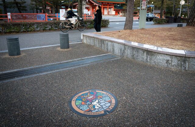 A manhole cover is decorated with a Heian Jingu Pokémon image.