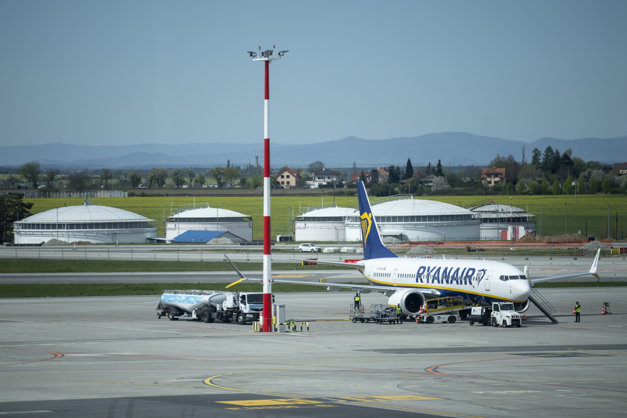 A fuel tanker by a passenger aircraft, operated by Ryanair Holdings Plc, at Vaclav Havel Airport in Prague, Czech Republic, on Saturday, April 25, 2026. Airlines around the world are raising prices for bags and seats, dialing back profit forecasts and openly discussing ways to link up with rivals as the chokehold from war-related fuel costs tightens. Photographer: Milan Jaros/Bloomberg