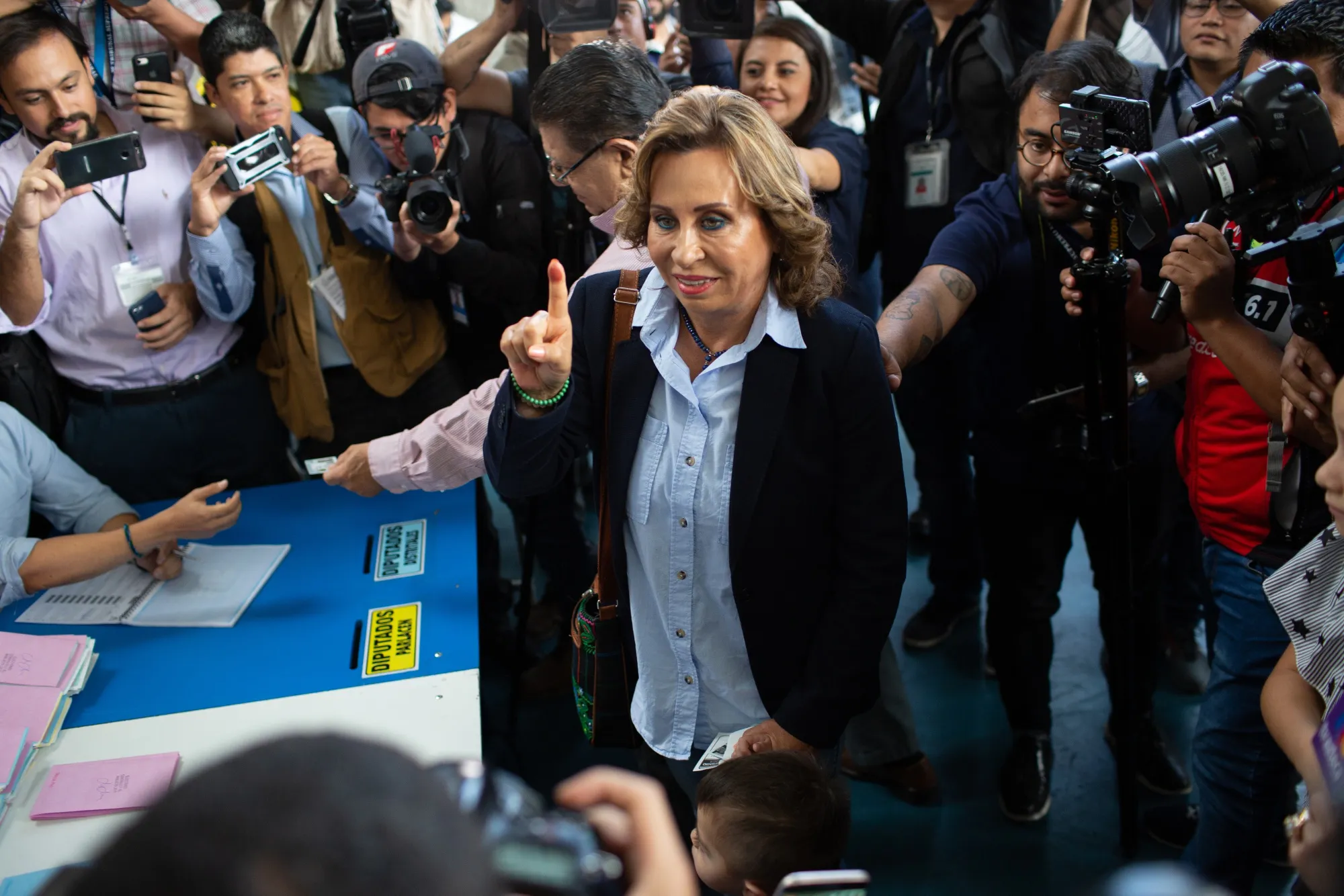 Sandra Torres displays an inked finger after voting on Sunday.