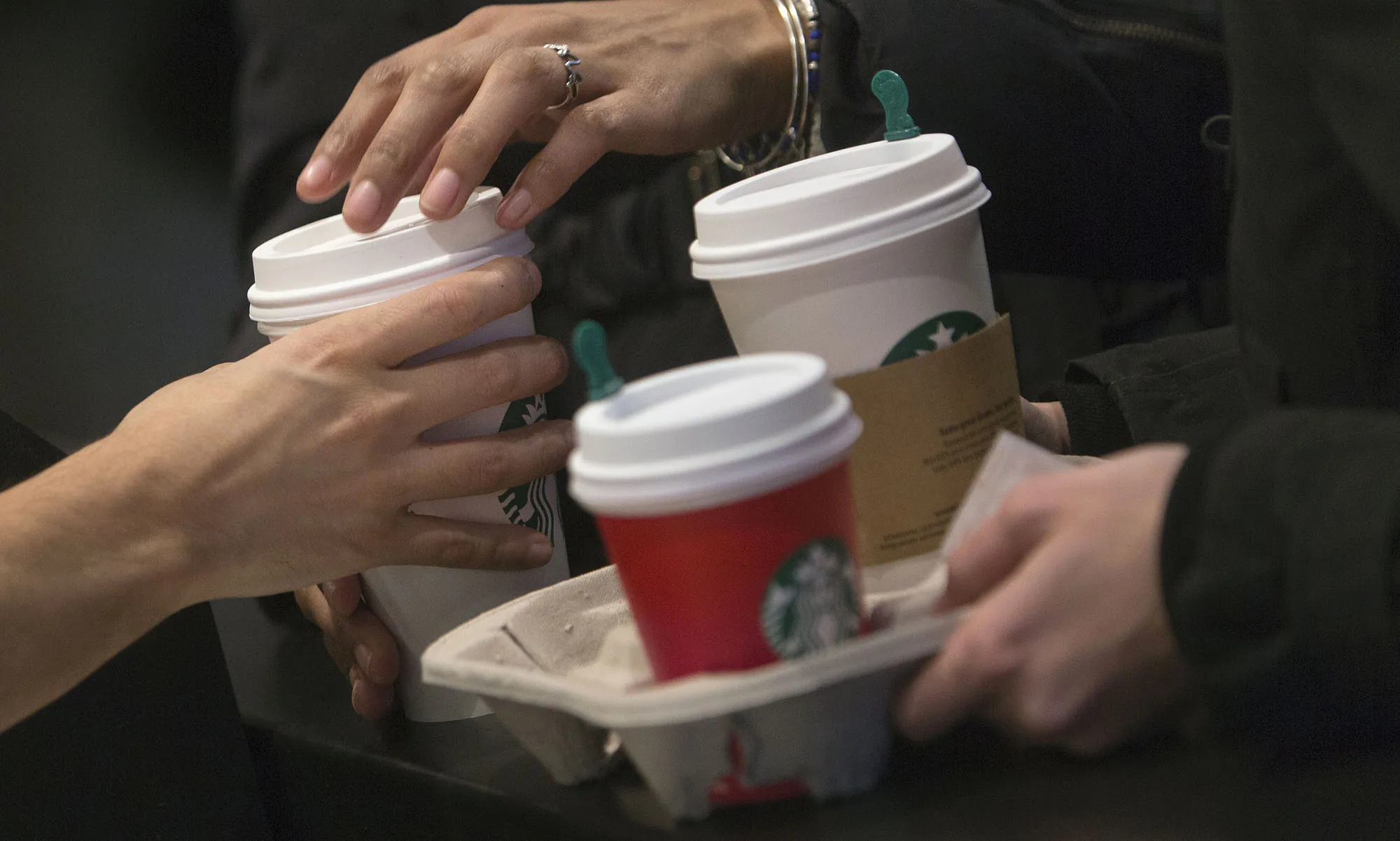 A barista hands a customer a drink inside a Starbucks coffee shop in New York.