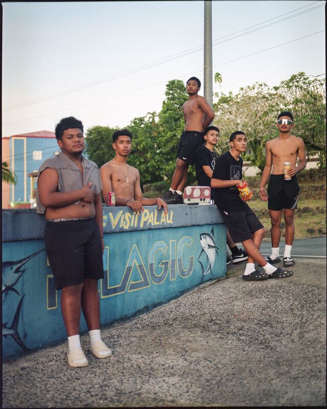 Young Palau residents, gathering by a mural promoting tourism