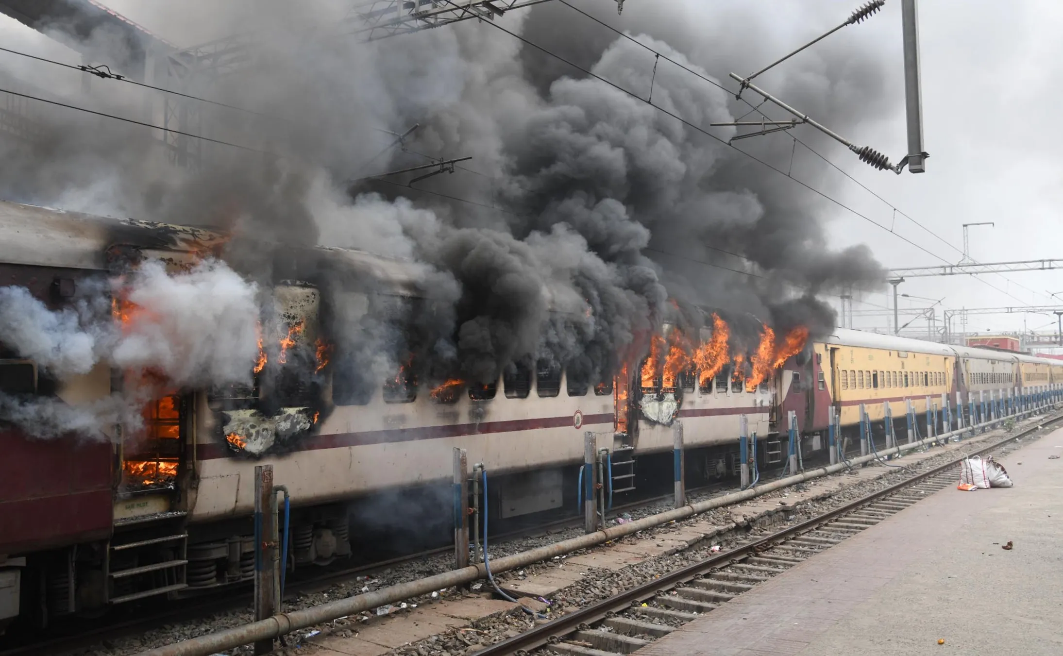 A train is set ablaze during a protest against the Agnipath army recruitment scheme in Patna on June 17.